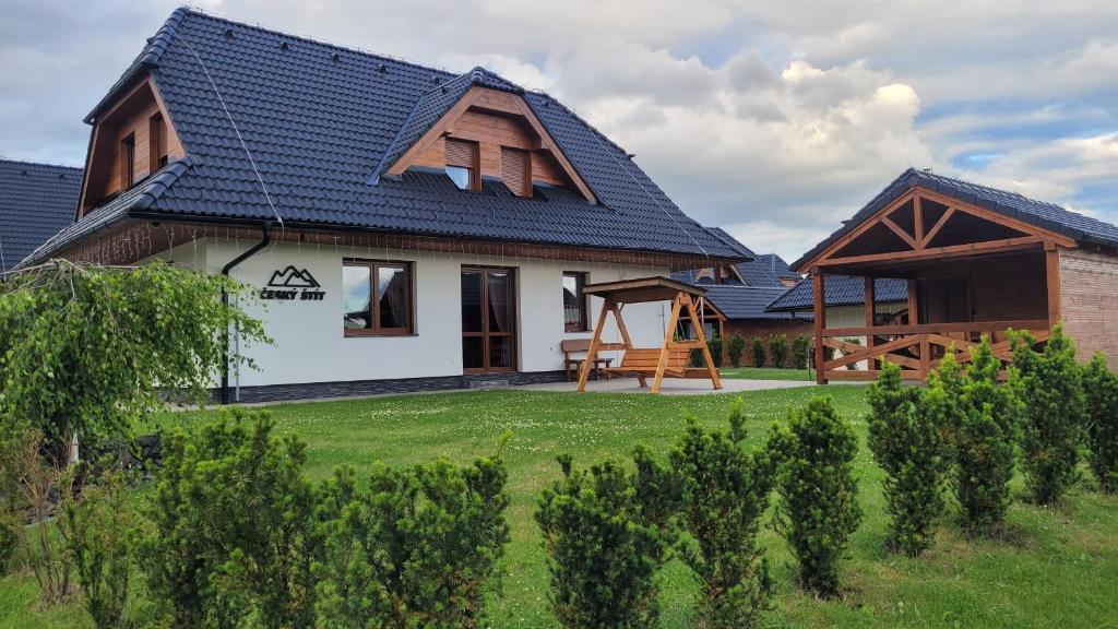 a house with a blue roof and a yard with trees at chalupa Český štít Vysoké Tatry in Stará Lesná