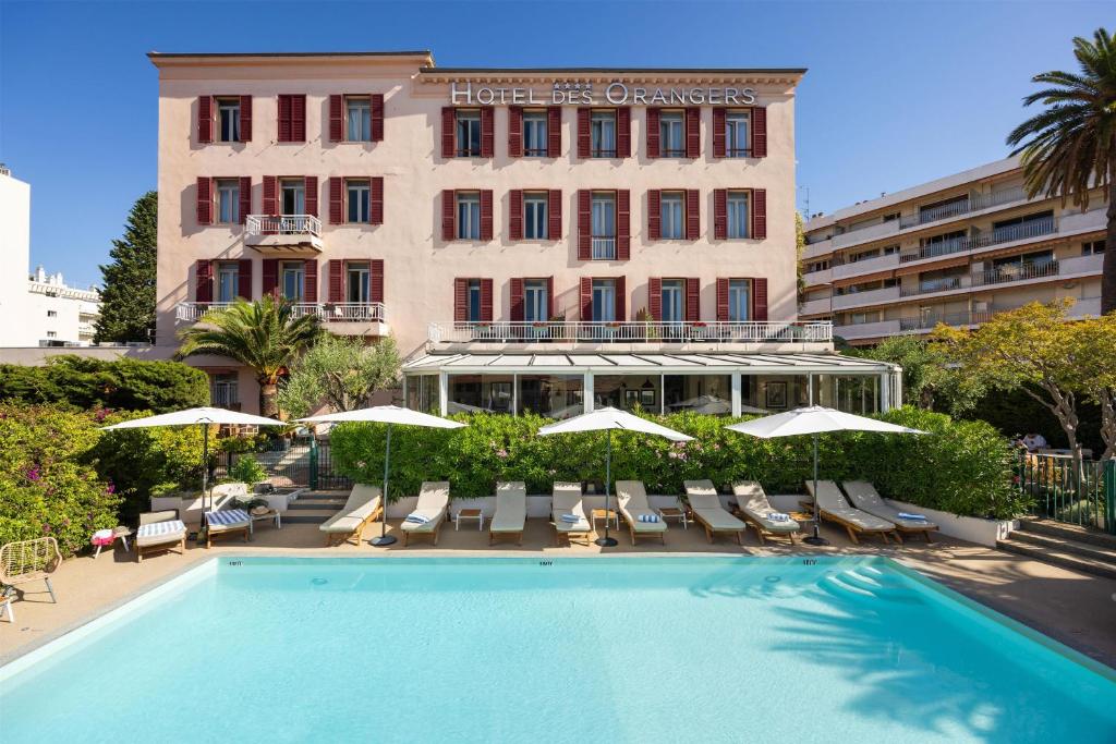 a hotel with a swimming pool in front of a building at Best Western Hôtel des Orangers Cannes in Cannes