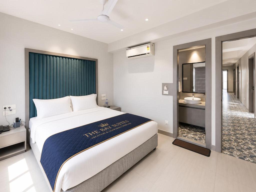 a bedroom with a large bed and a bathroom at The Bay Suites - MMR in New Town