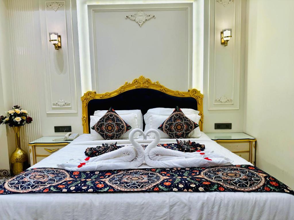 a bed with two swans made out of towels at Hotel The Raghavas' in Ayodhya