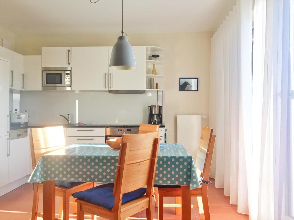 eine Küche mit einem Tisch und Stühlen in der Unterkunft Kurparkcarree - Ferienwohnung "Amber" in Juliusruh