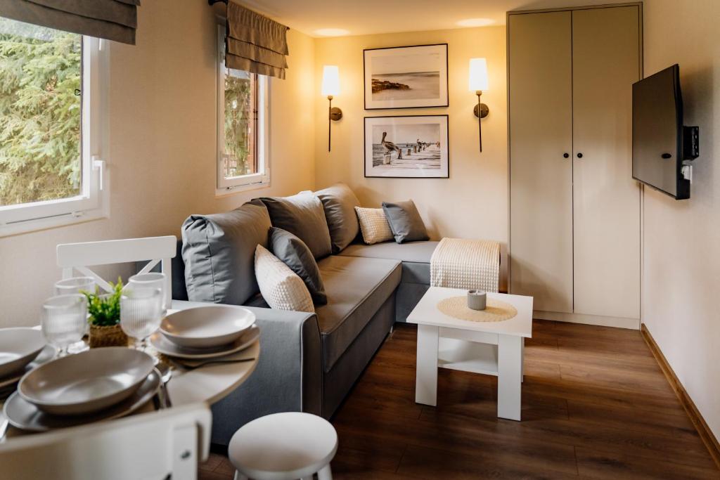 a living room with a couch and a table at Sosnowe Tarasy in Boszkowo-Letnisko