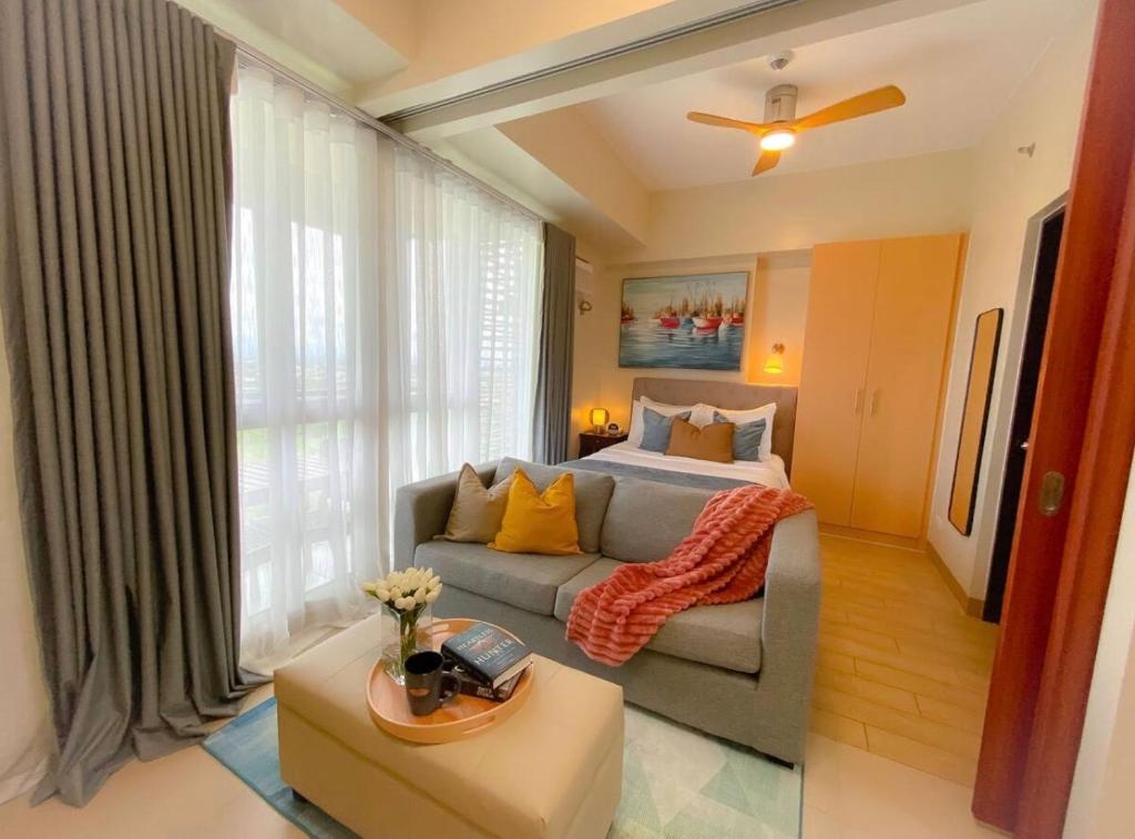 a living room with a couch and a bed at Paladium Iloilo Smart Home Condo in Iloilo City