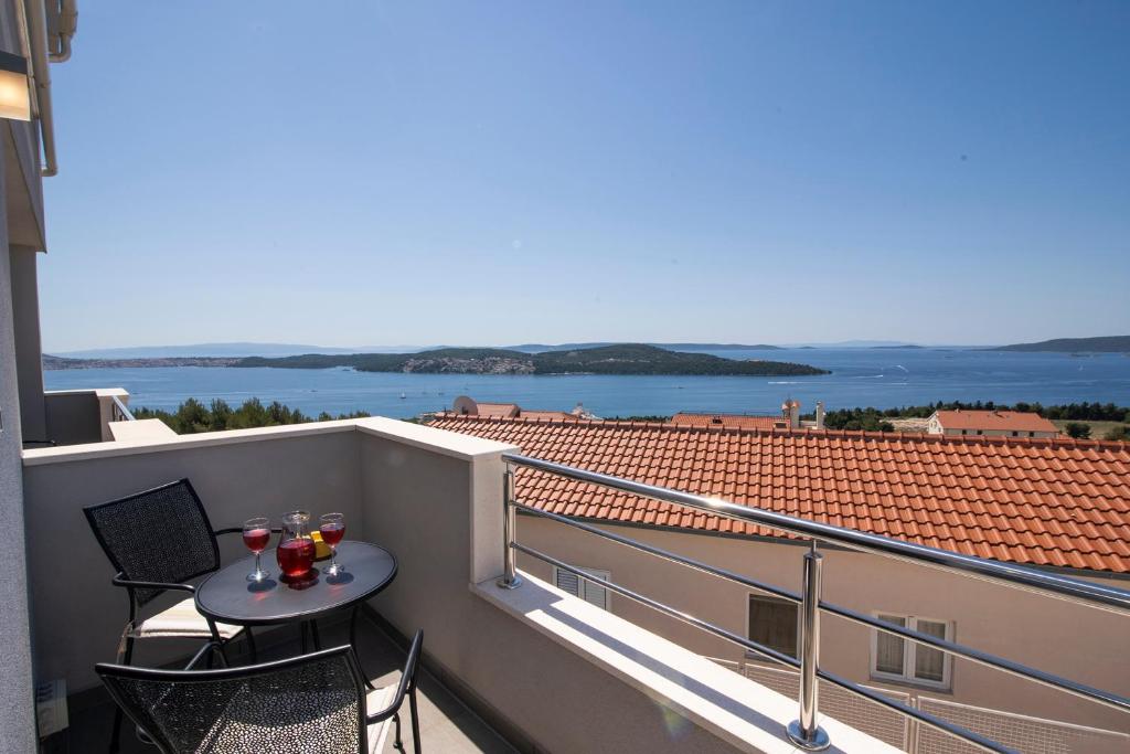 a balcony with a table and two glasses of wine at Apartments Vini in Donji Seget