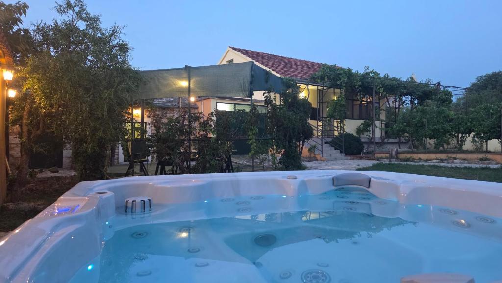 a hot tub in front of a house at Krka Hideaway in Lozovac