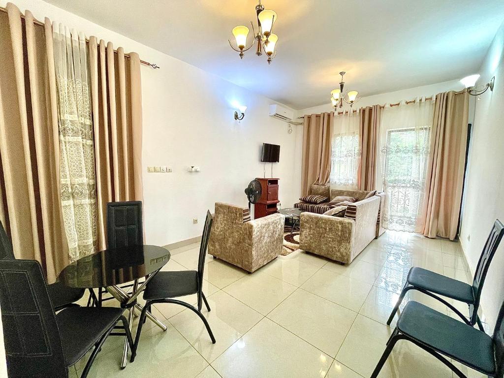a living room with a table and chairs at Résidence T&M ODZA Yaoundé Cameroun in Méhandan