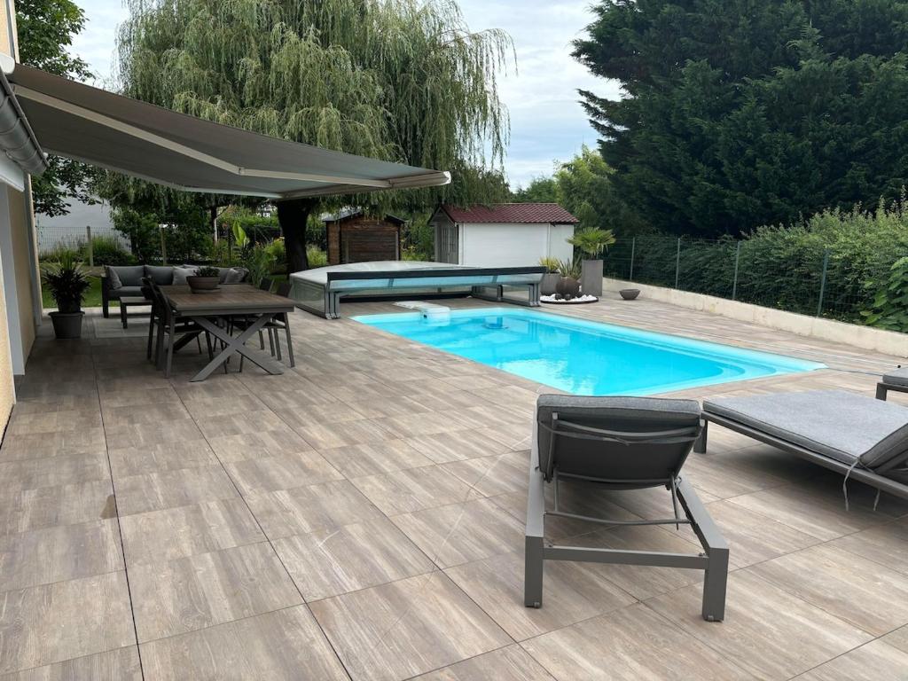 a patio with a table and chairs and a pool at Studio piscine in Puy-Guillaume