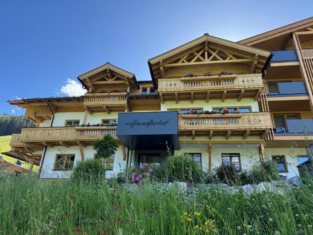 a large building with balconies on top of it at Gasthof Hotel Handlerhof in Maria Alm am Steinernen Meer