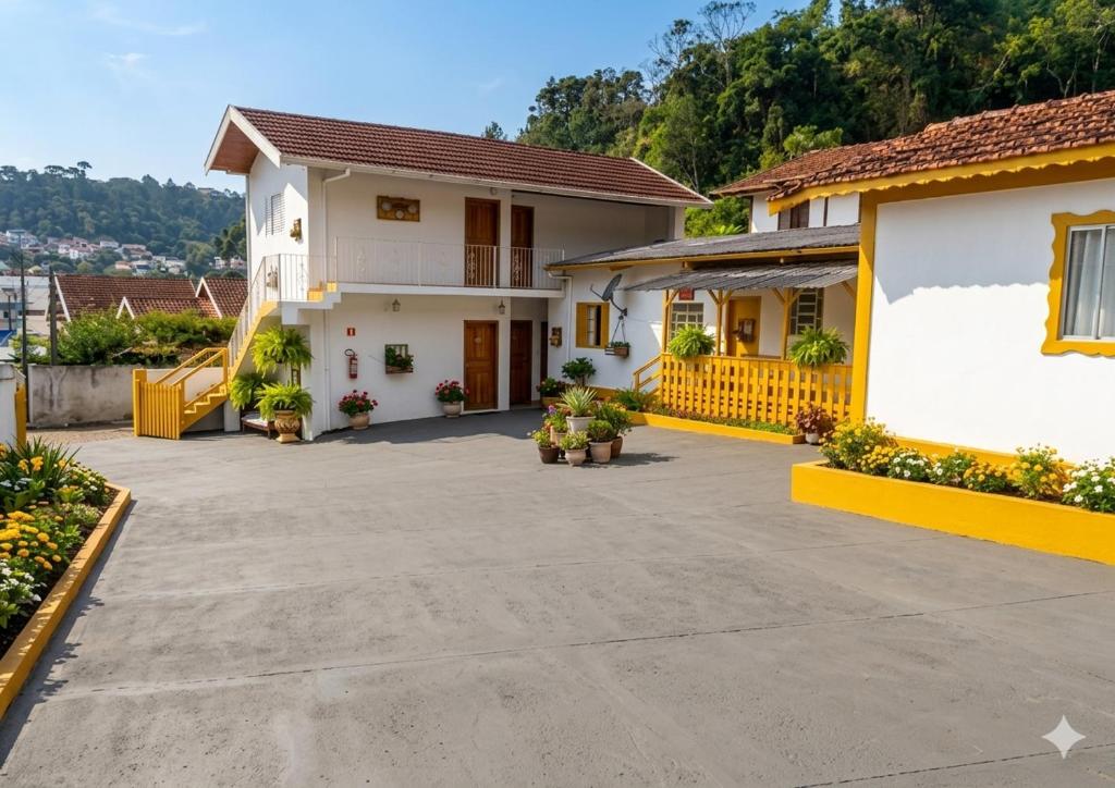 a house with a large courtyard with potted plants at Marins Pousada - Campos do Jordão in Campos do Jordão