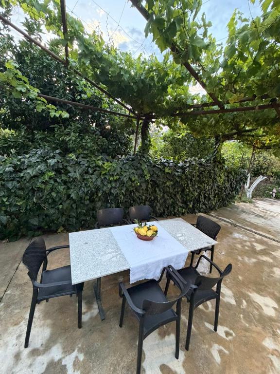 a table and chairs with a bowl of fruit on it at The Hidden Orchard near Saranda in Delvinë