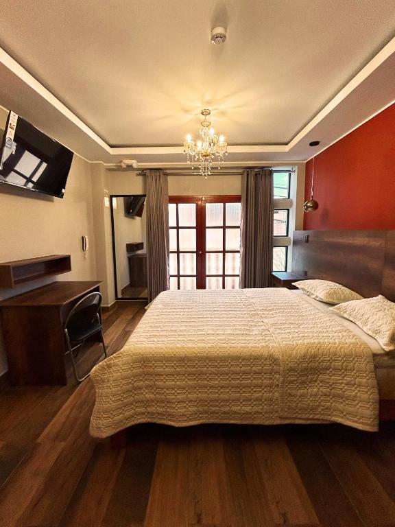 ein großes Schlafzimmer mit einem großen Bett und einem Schreibtisch in der Unterkunft Ukumari Hotel in Chachapoyas