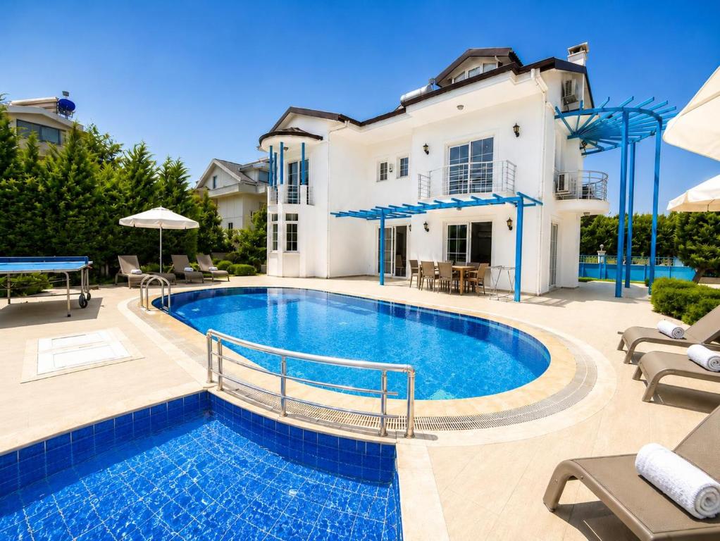 a swimming pool in front of a house at Villa Fergana in Oludeniz