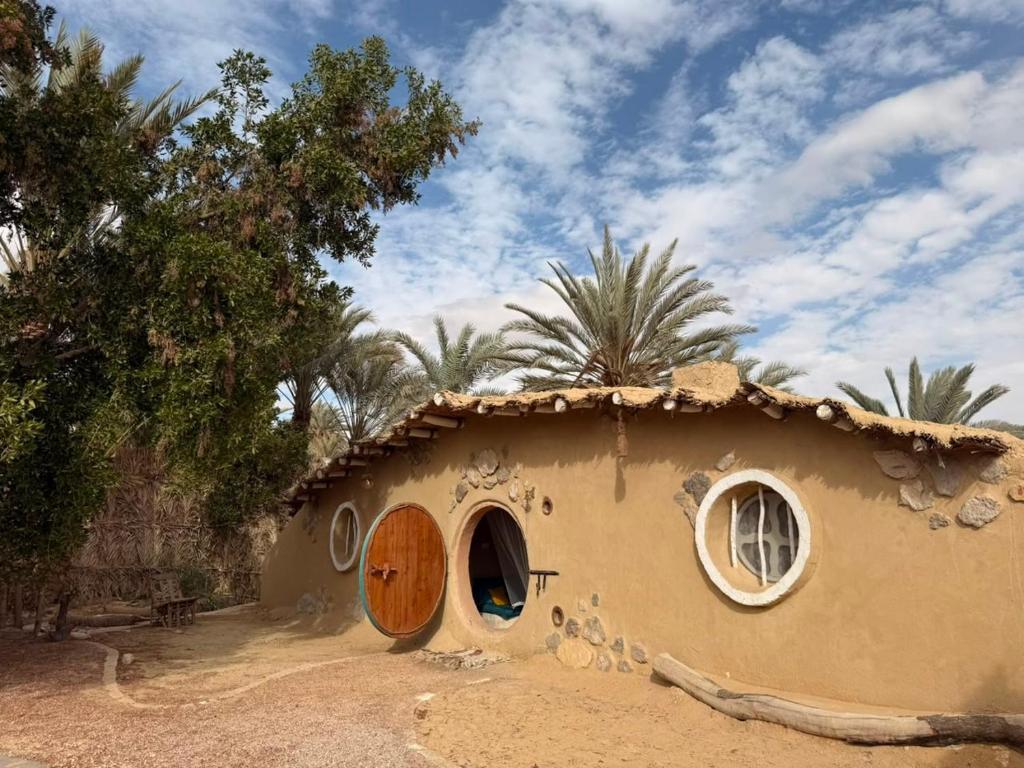 a small house with a door in the dirt at Hobbit-Hole in Siwa in Siwa