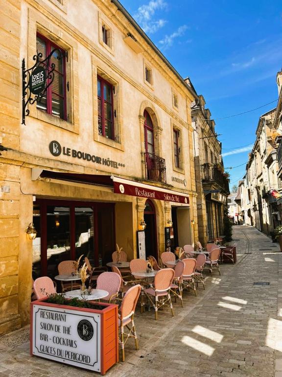 an empty street with tables and chairs outside a building at Logis Hôtel Le Boudoir in Belvès