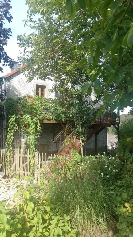 an old stone house with ivy growing on it at La Grange in Fter