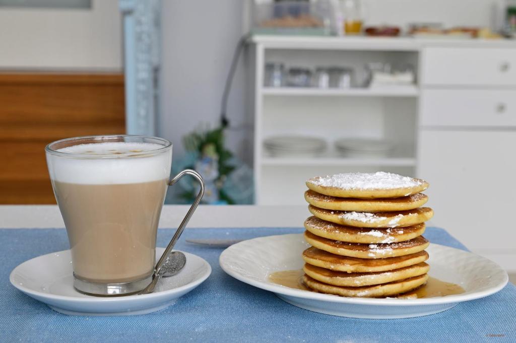 a stack of pancakes on a plate next to a cup of coffee at Pepe'Accommodation in Parghelia