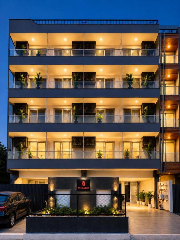an apartment building with a car parked in front of it at Hotel Mikado Palace in Gurgaon