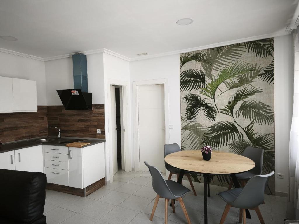 a kitchen and dining room with a table and chairs at Apartamentos Joli in Olivares de Duero