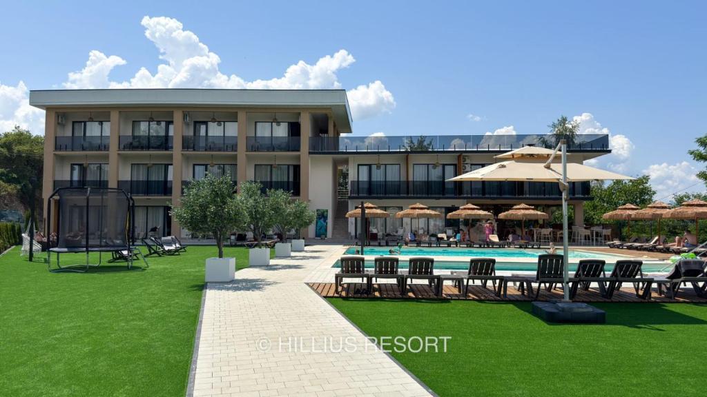 a resort with a swimming pool and chairs and a building at HILLIUS Resort in Solotvyno