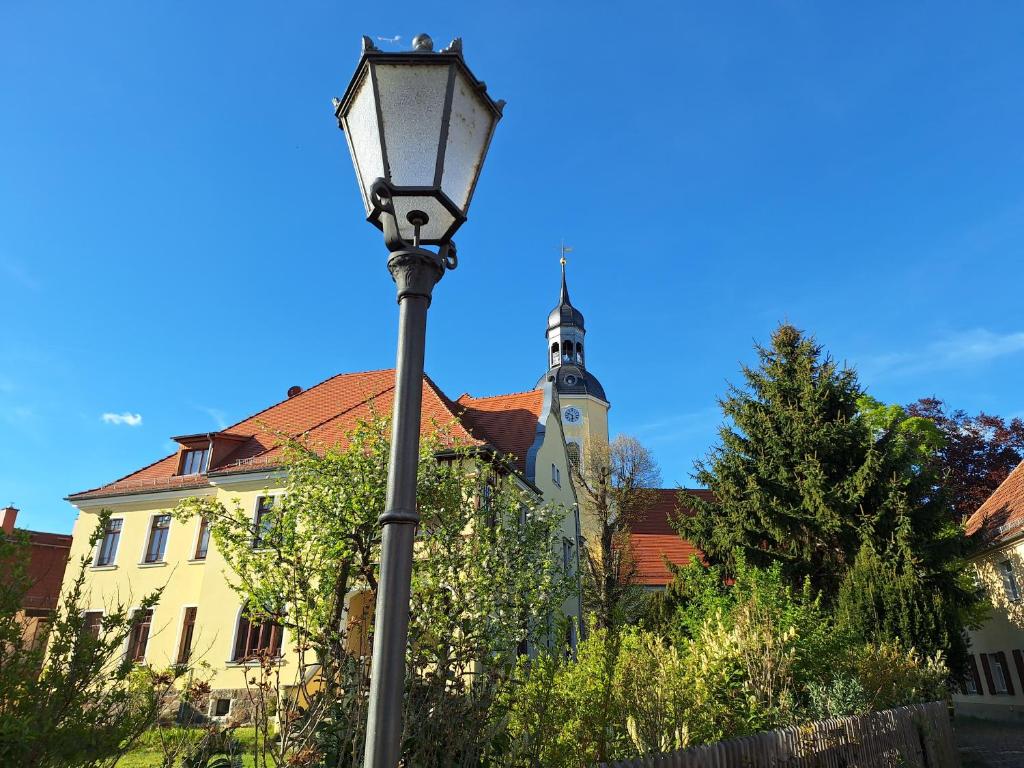 a street light in front of a building with a church at Kleinstadt-Fritz in Radeburg