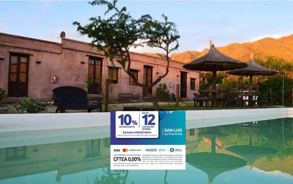 a sign in front of a house with a swimming pool at Los Remolinos in Merlo