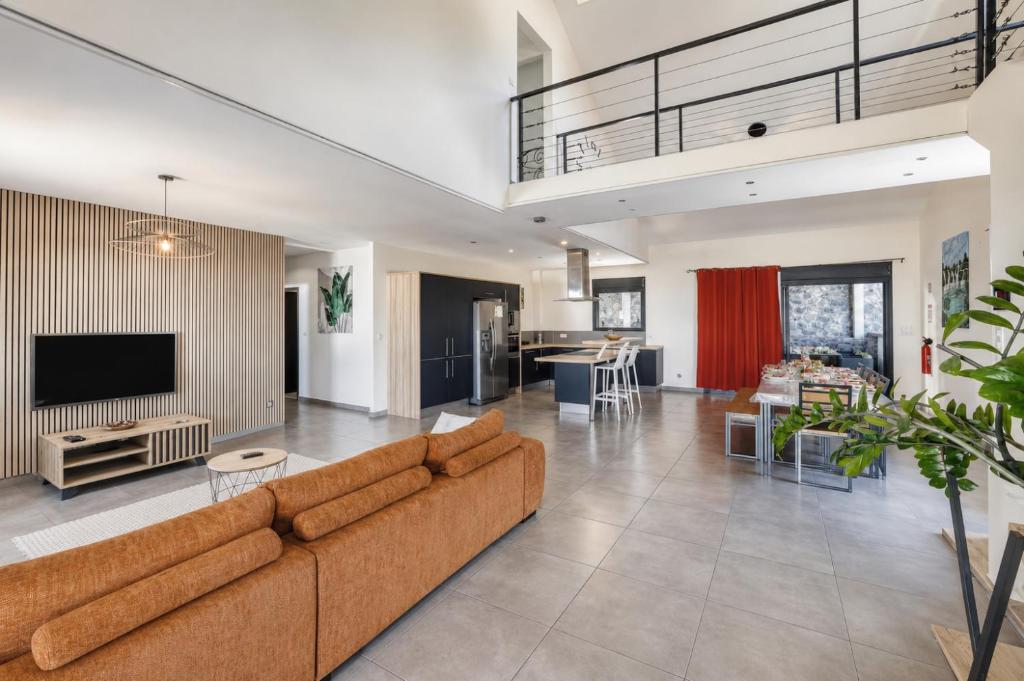an open living room with a couch and a tv at Villa Ô Ti Paille-en-queue - 14 voyageurs in Saint-Joseph