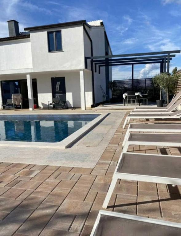 a house with a swimming pool and a patio at Villa Klara in Gedići