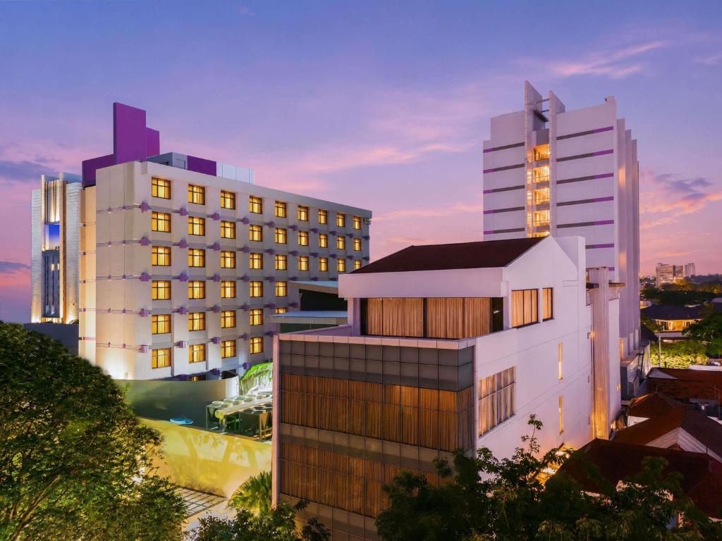 two tall buildings in a city at dusk at Mercure Surabaya Grand Mirama in Surabaya
