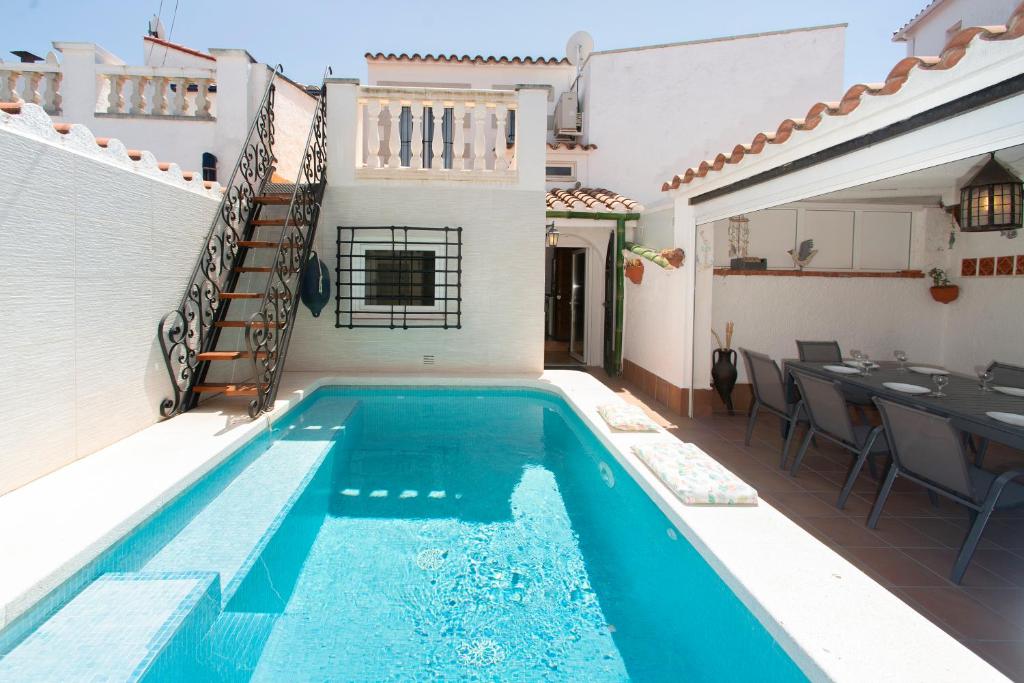 a villa with a swimming pool and a dining area at WELCS CASA 357 EMP con piscina privada in Empuriabrava