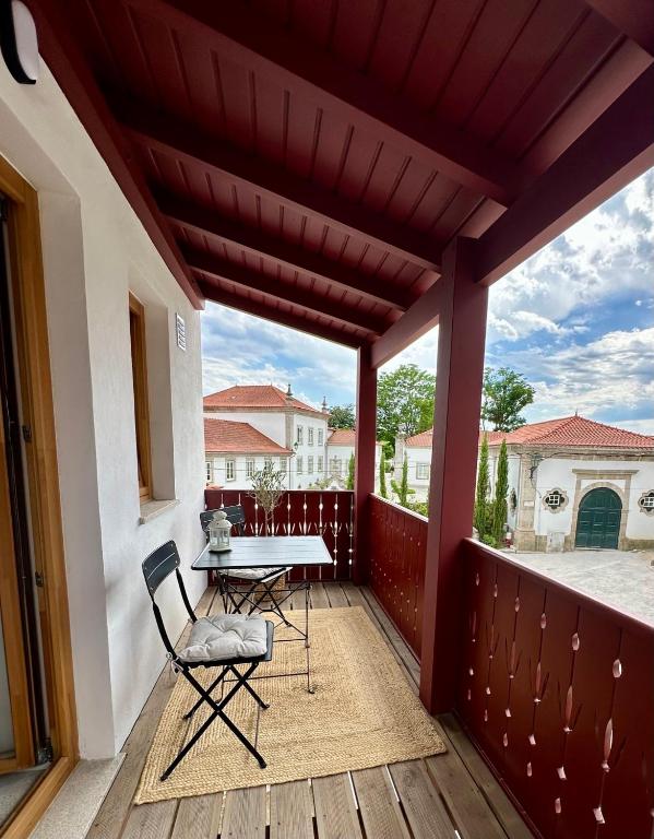 a patio with a table and chairs on a deck at Casa N'Aninhas - Santar in Santar