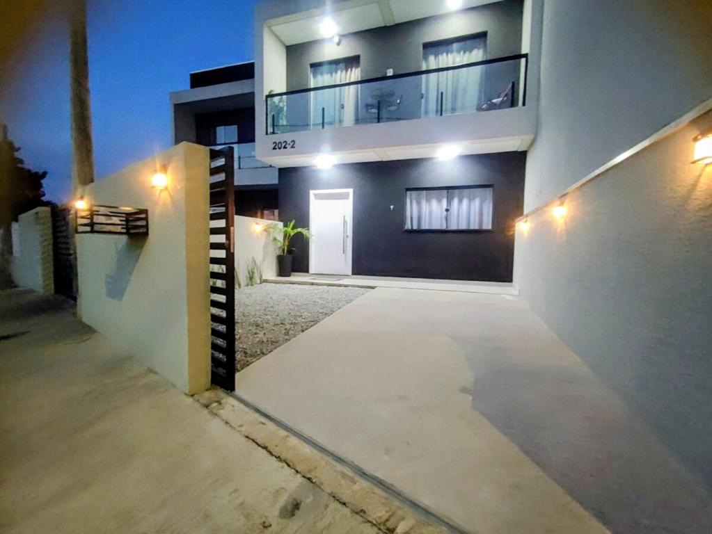 a large house with a driveway in front of it at Sobrado Matinhos 480 m da praia l novo l central 3quartos in Matinhos