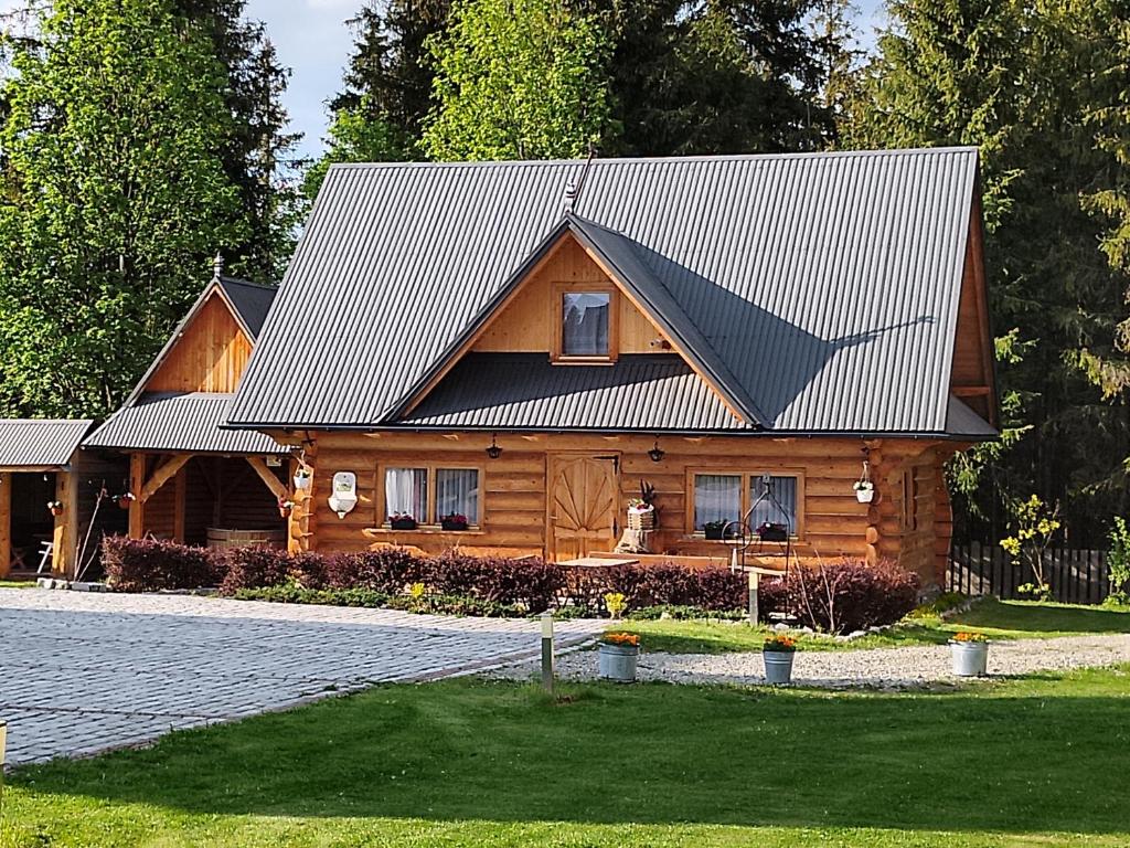 a log cabin with a metal roof on a house at Domek góralski Toporówka in Murzasichle