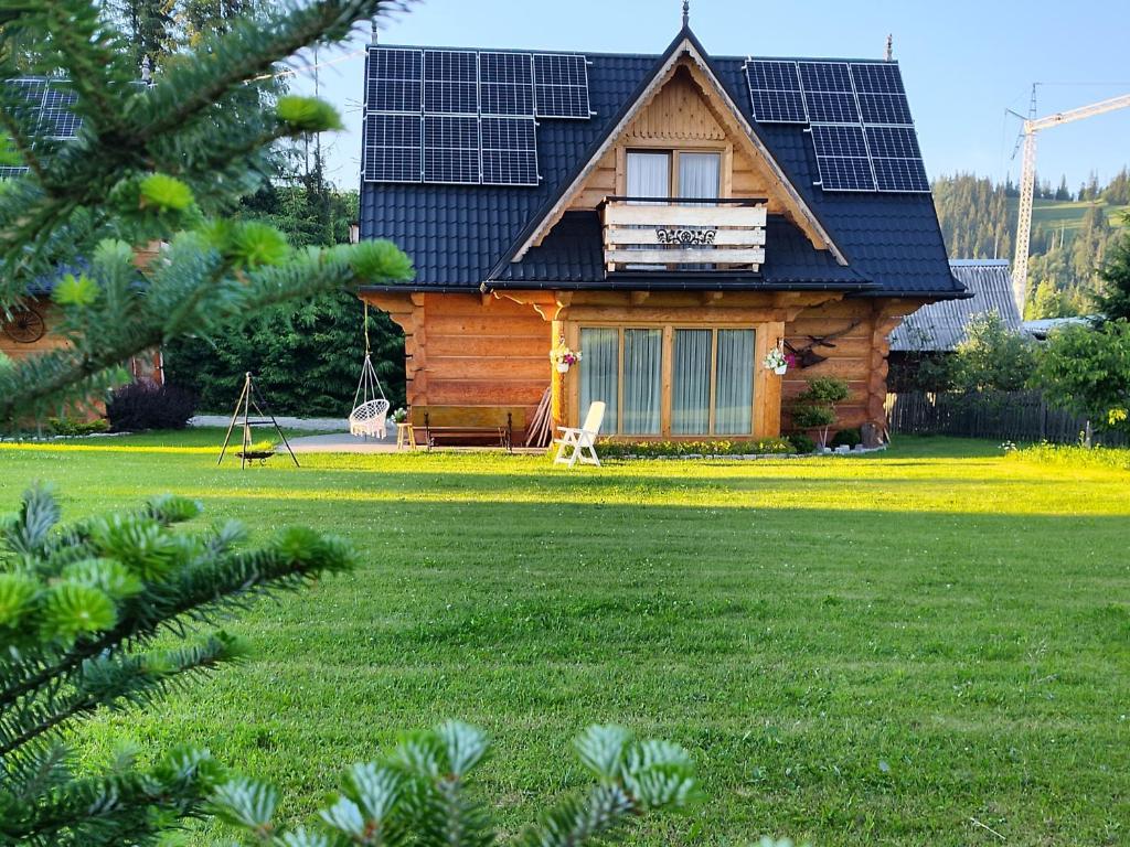 a log cabin with solar panels on the roof at Domek góralski Toporówka - Premium in Murzasichle
