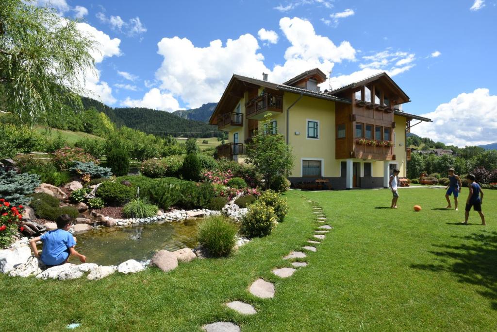 a group of people playing soccer in the yard of a house at Agritur Maso Chemela in Cavalese