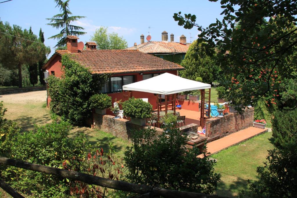 a red house with a white umbrella in a yard at Le Giunchete in Cavriglia