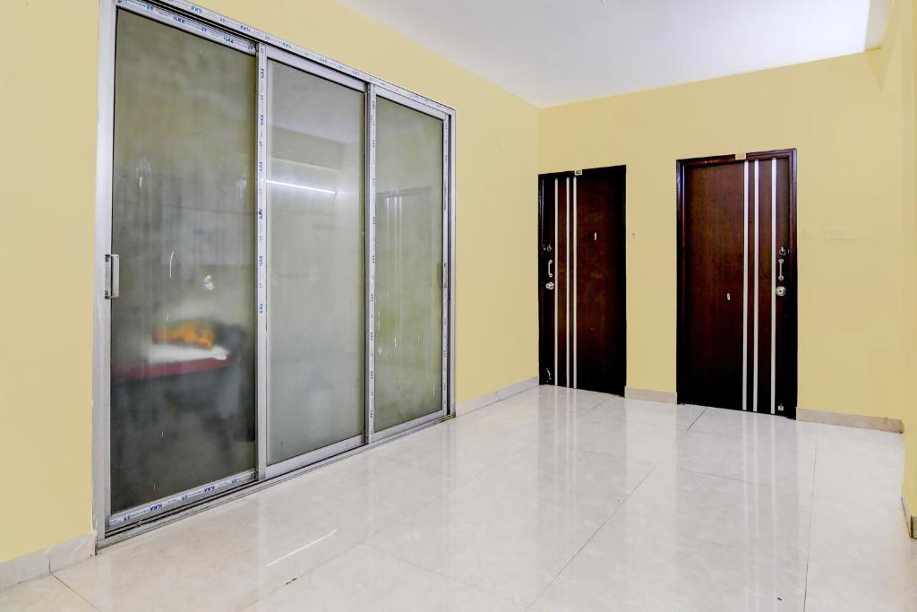 a room with three glass doors and yellow walls at Hotel O MAJESTIC M2 INN in New Town