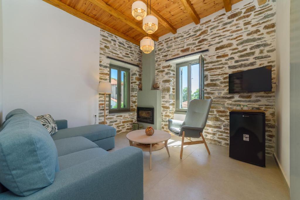 a living room with a blue couch and a stone wall at Orange House - Upper East apartment in Promírion