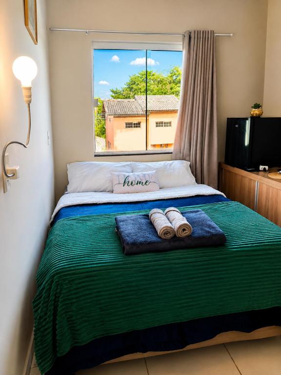 a bedroom with a bed with two towels on it at Quarto tranquilo e confortável dentro de residência particular, 3 km do Aeroporto , 1,5 km da Praia in Navegantes