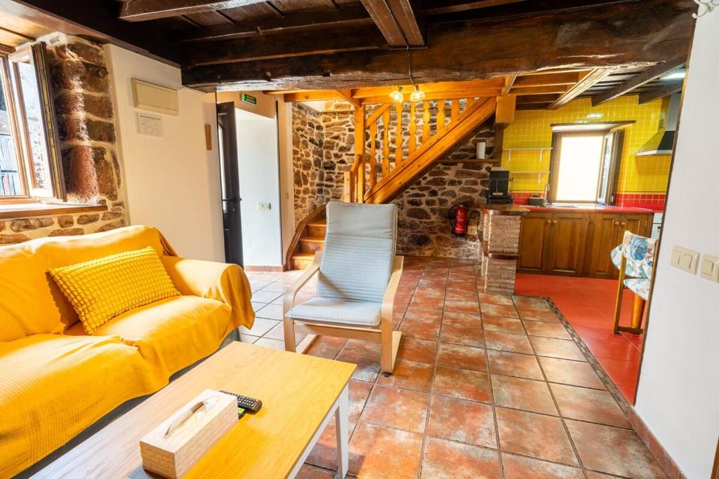 a living room with a yellow couch and a table at El Llagar de Ternín in Villaviciosa