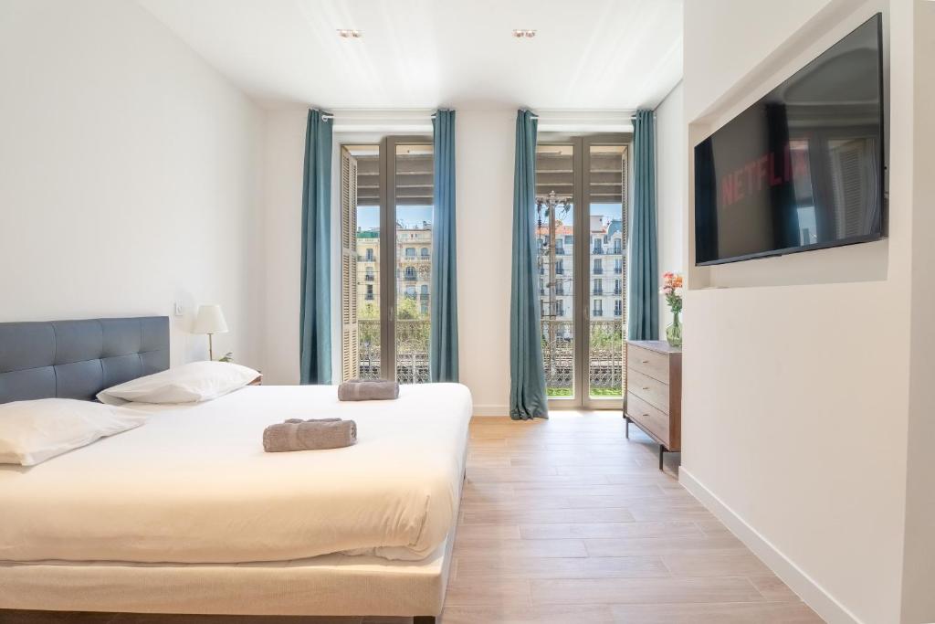 a bedroom with two beds and a flat screen tv at Maison Rouget - Chambre 1 - Mimosa in Nice
