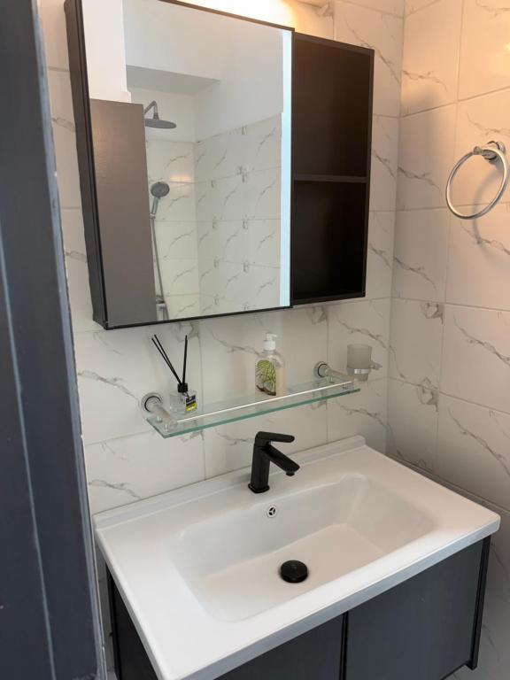 a bathroom with a white sink and a mirror at Harmonie in Abidjan