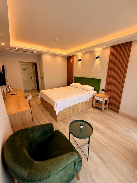 a bedroom with a bed and a chair and a couch at Ovva Inn Yeşilovacık Hotel in Dibekli