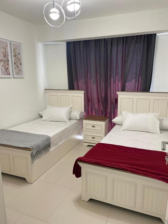 a bedroom with two beds and a window at Marassi in El Alamein