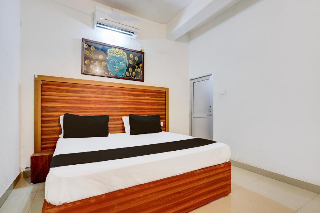 a bedroom with a large bed with a wooden headboard at Hotel O Royal in Rewāri