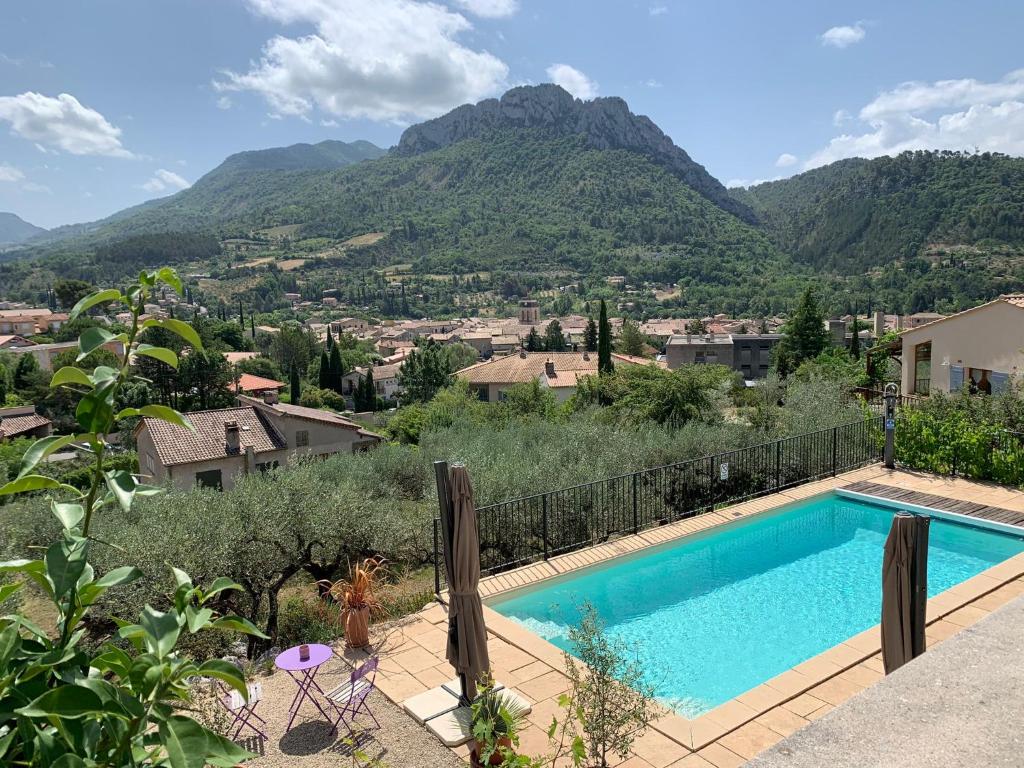 a swimming pool with mountains in the background at Le mas christiane in Buis-les-Baronnies