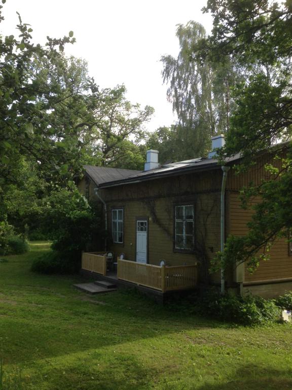 a small house with a porch in a yard at Ruissalo Cottage in Turku