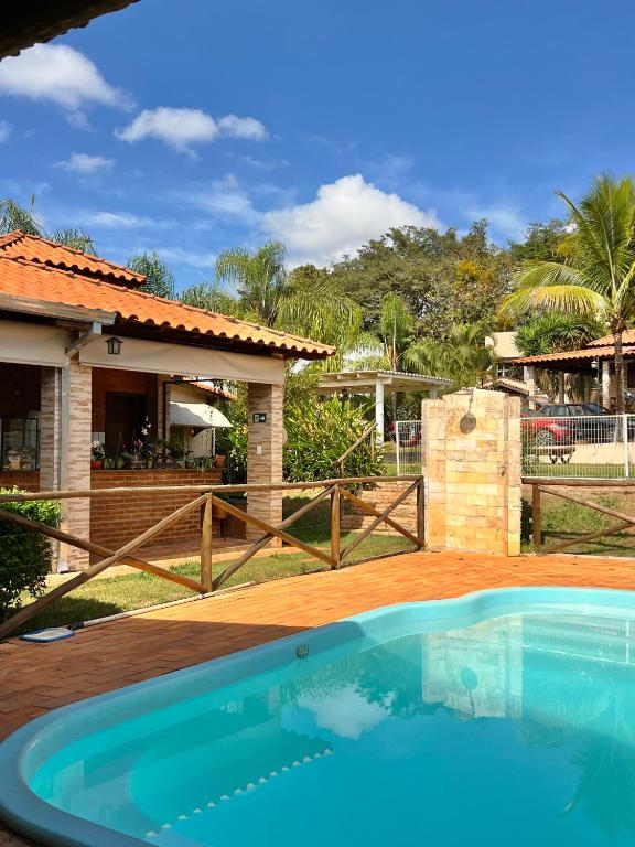 a swimming pool in front of a house at Pousada Estância Mineira in Guapé