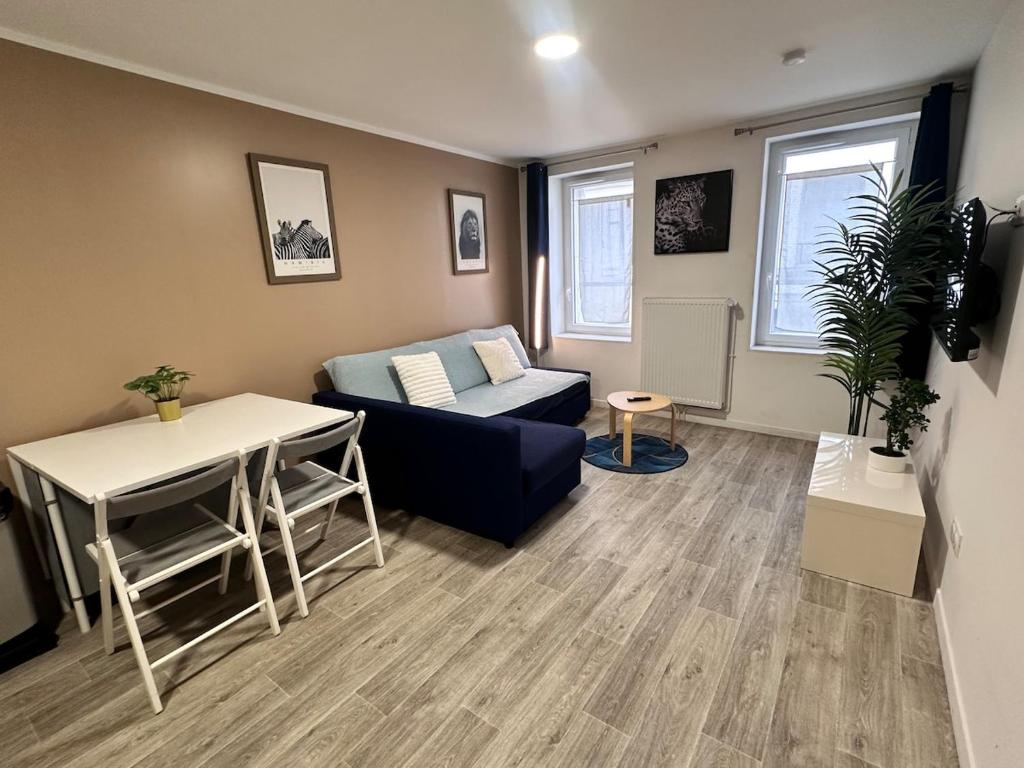 a living room with a couch and a table at Studio cosy au vieux centre in Cormeilles-en-Parisis
