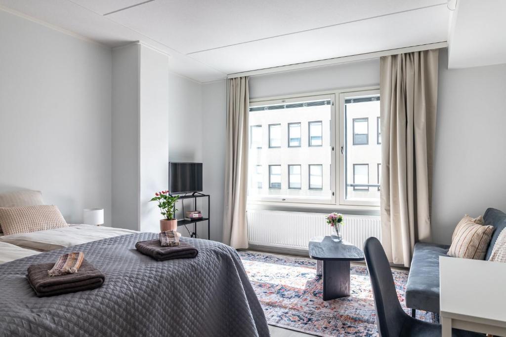 a white bedroom with a bed and a window at Modern Studio in Downtown Lahti in Lahti