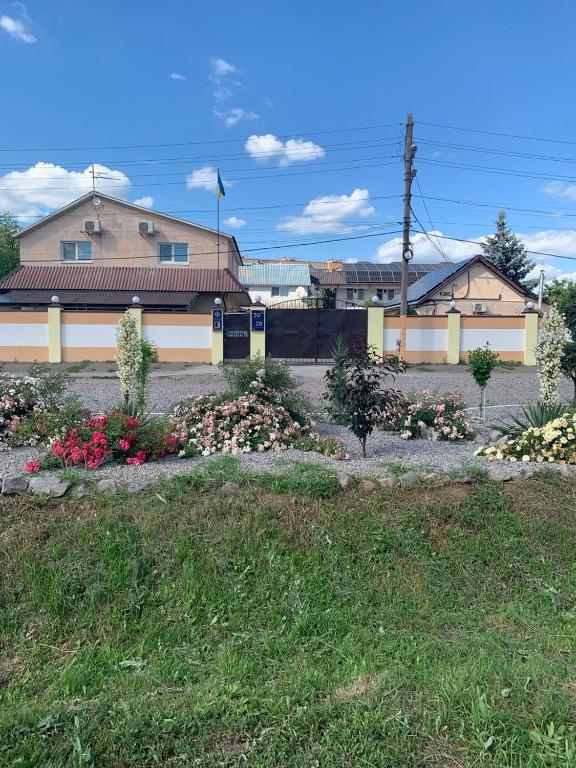 a building with a bunch of flowers in a yard at Ночівля in Poltava